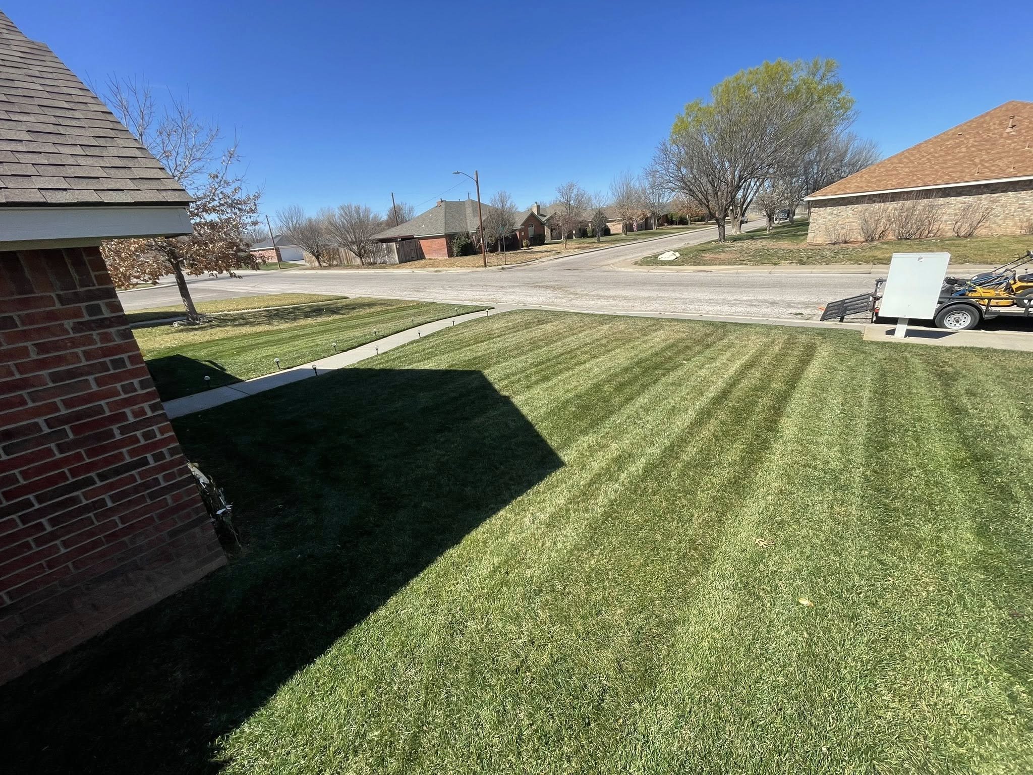 Freshly edged residential lawn showing clean driveway border in Greater Sudbury Ontario