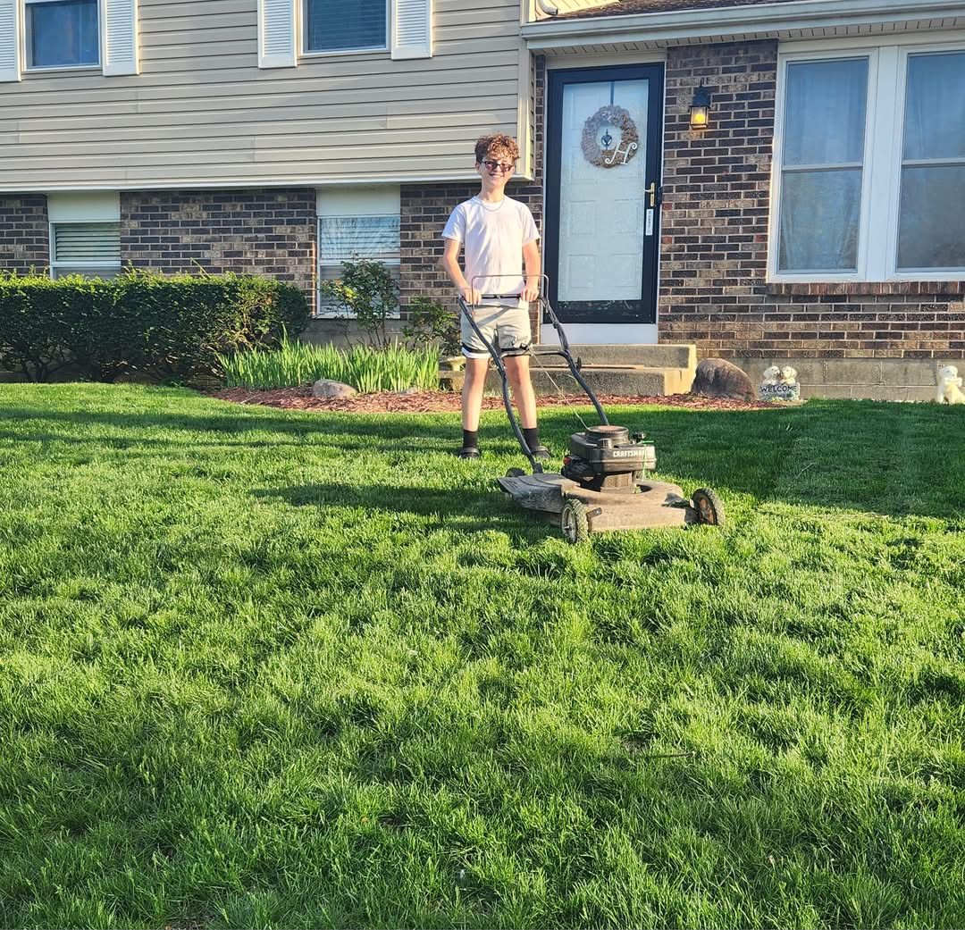 Homeowner checking mower deck height on driveway in Sudbury Ontario