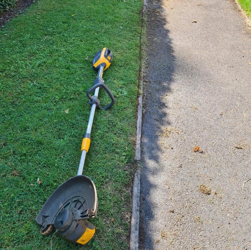 Lawn edging tools — stick edger and string trimmer on a Sudbury property
