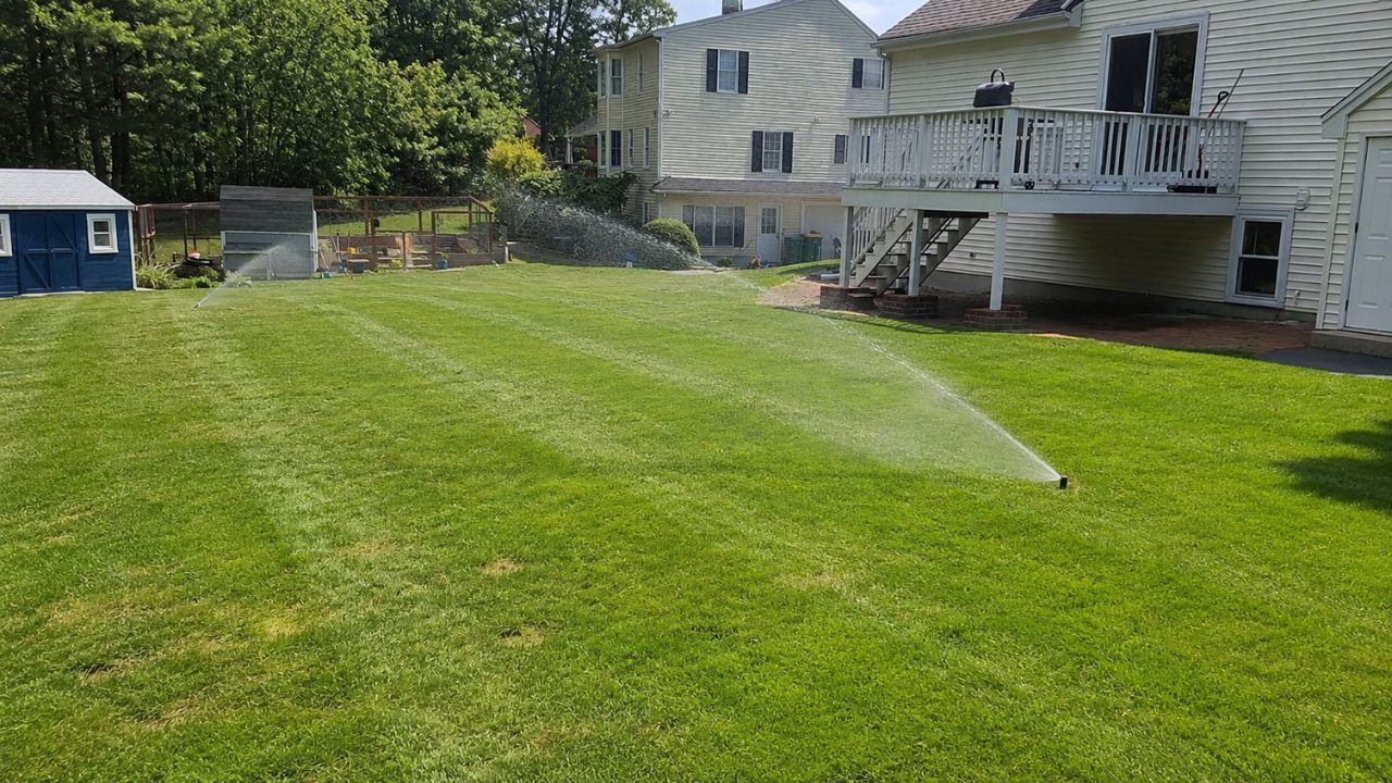 Residential sprinkler system watering a green lawn in Sudbury Ontario