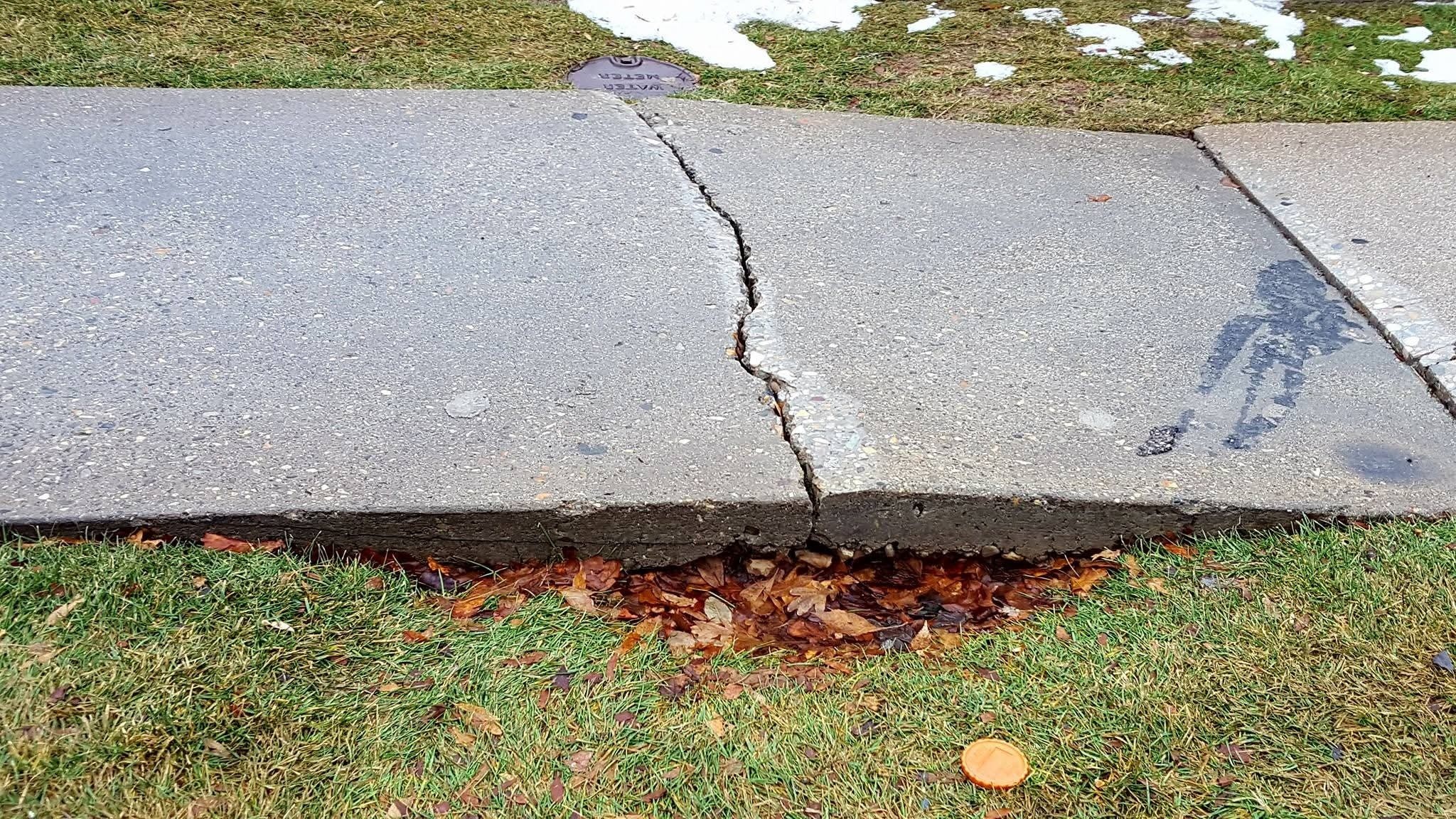 Stone pathway showing frost heave damage in a Sudbury Ontario yard in spring