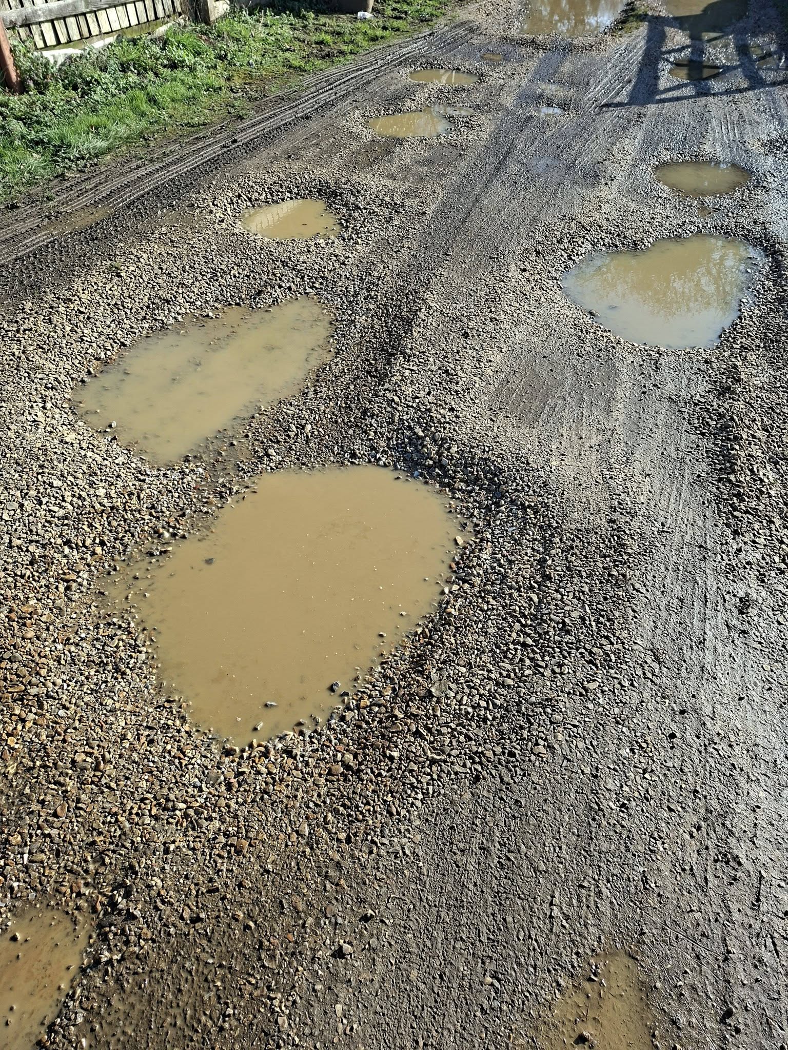 Gravel driveway repair filling potholes and regrading worn sections in Sudbury