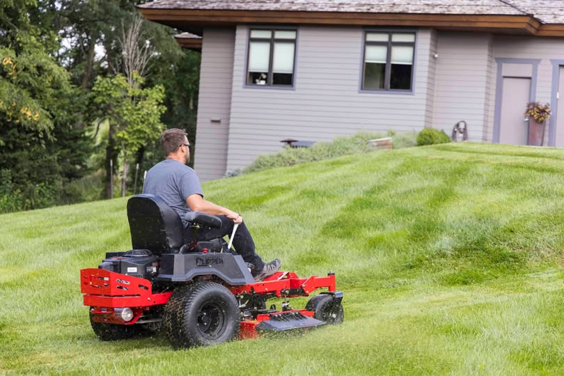 Homeowner on push mower on large Sudbury Ontario residential property