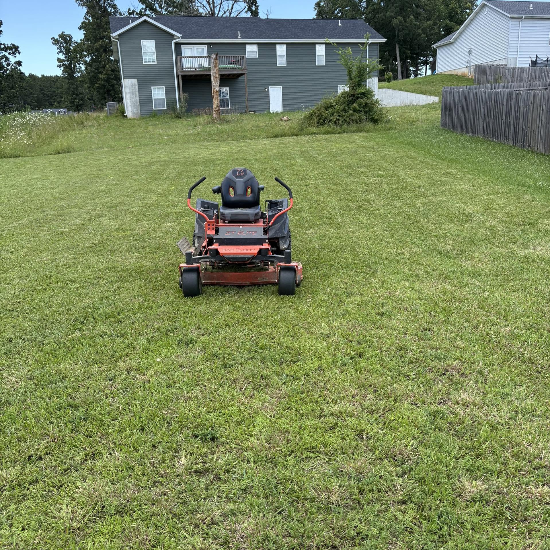 Lawn care crew mowing trimming and edging a Sudbury residential lawn