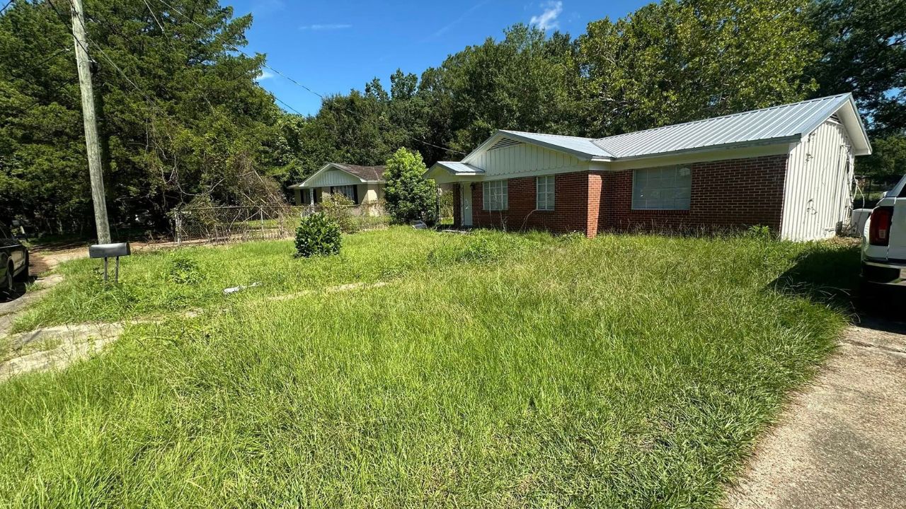 Neglected overgrown lawn on a Sudbury Ontario residential property in summer