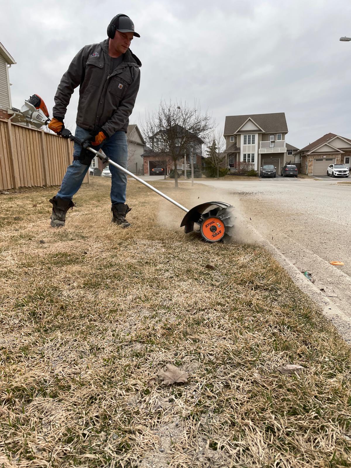 Professional grass cutting being done on a residential lawn in Greater Sudbury