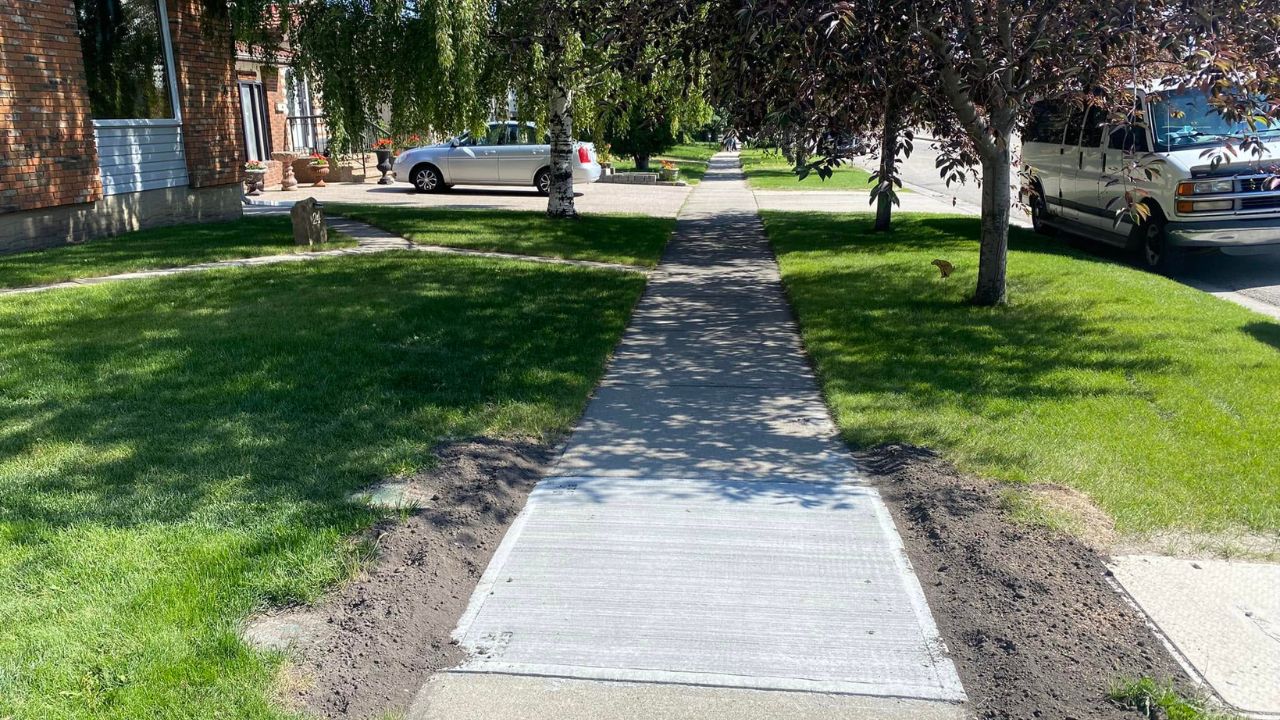 Ryan Lingenfelter and Sudbury homeowner walking residential lawn together during property assessment