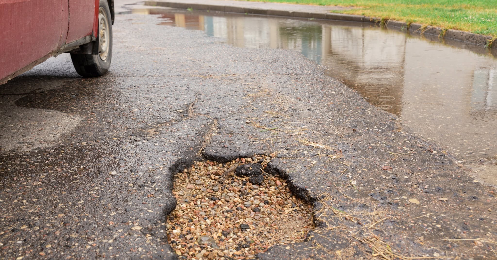 Vehicle damage from deep pothole on a poorly maintained Sudbury Ontario gravel driveway in spring