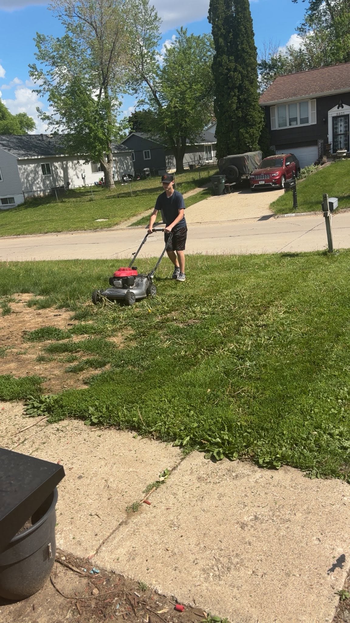 Young lawn care worker learning basic mowing technique at first property in Sudbury Ontario