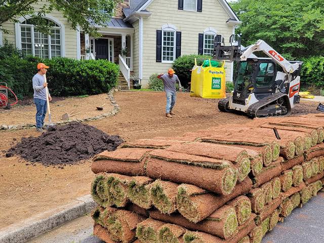 Lawn contractor tilling and preparing clay soil before sod installation on a Sudbury residential property
