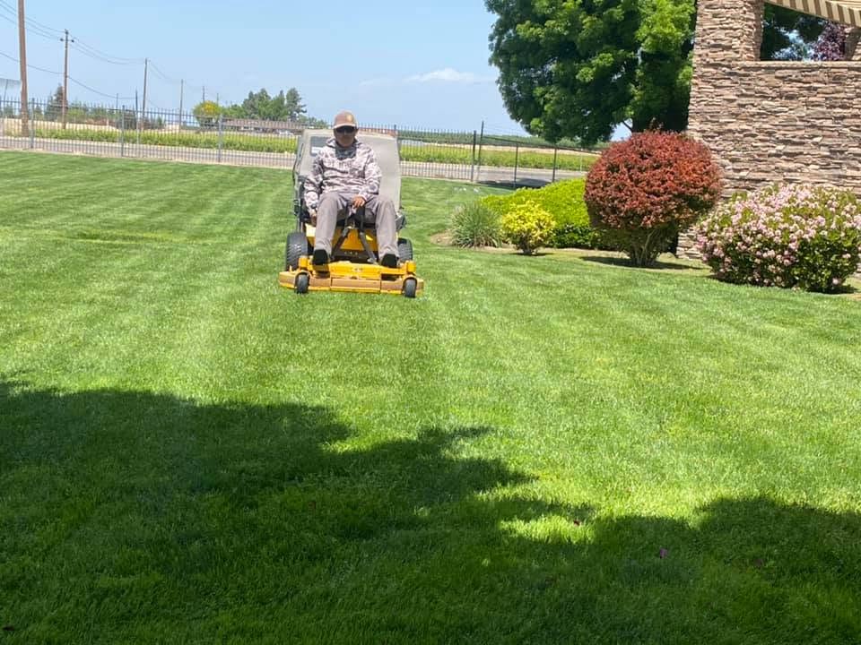 Professional lawn care crew mowing and edging a Sudbury Ontario residential property in 2026