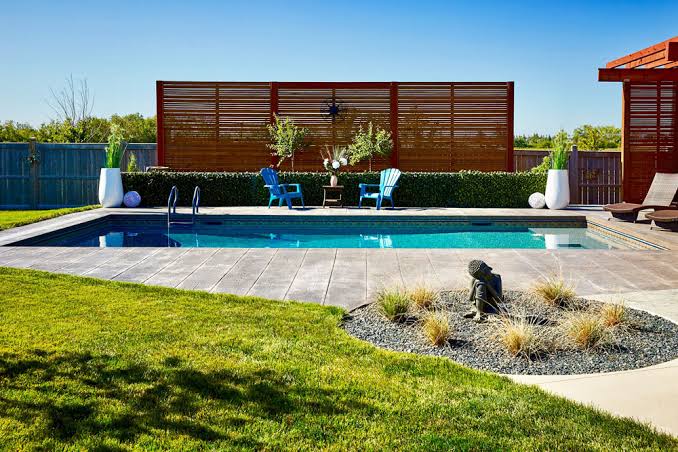 plywood sheet lumber and pool cover left on residential lawn in Sudbury Ontario summer